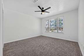 A room with a ceiling fan and a window with blinds.