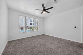 A room with a ceiling fan and a window with blinds.