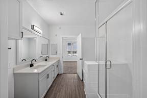 A white bathroom with a walk in shower.