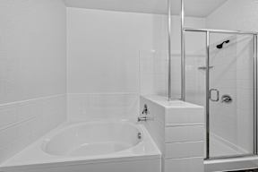 A white bathroom with a tub and shower.