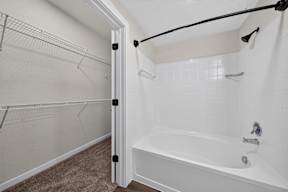 A white bathroom with a tub and a walk in shower.