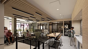 A modern dining area with people sitting and standing around the tables.