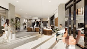 A group of people are standing and sitting in a modern lobby area.