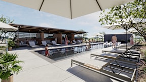 A pool area with sun loungers and a shaded area.
