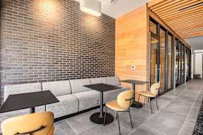 A modern cafe with a brick wall and wooden ceiling.