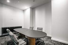 A conference room with a table and chairs.