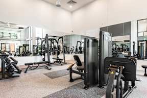 A gym with a variety of equipment including treadmills, weights, and exercise machines.