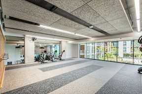 A spacious gym with a variety of exercise equipment and a view of the outdoors.