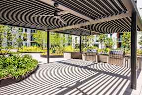 A patio with a roof and a fan.