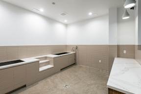 A modern bathroom with a large marble countertop and a bathtub with a built-in shower.