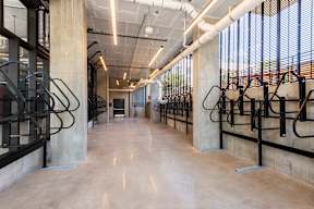 A long hallway with concrete pillars and metal railings.