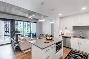 A modern kitchen with white cabinets and a large island.