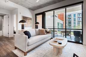 A modern living room with a white couch and a large window.