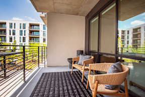 A balcony with two chairs and a table.