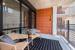 A balcony with a chair and a pillow.