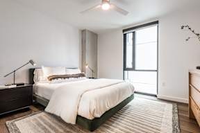 A bedroom with a large bed and a ceiling fan.