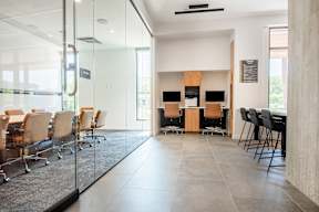 A conference room with a glass wall and a long table with chairs.