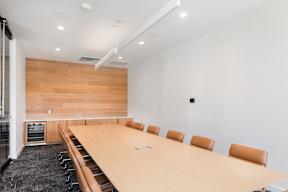 A conference room with a long table and chairs.