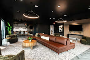 A modern living room with a brown leather couch and a wooden coffee table.