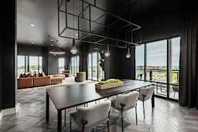 A modern dining room with a long table and chairs.