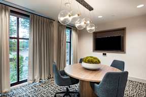 A conference room with a table, chairs, and a television.