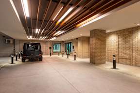 A car is parked in a garage with brick walls and ceiling.
