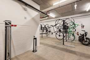 A room with a white wall and a bicycle rack with bikes.