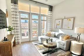 A living room with a grey couch, a coffee table, and a painting on the wall.