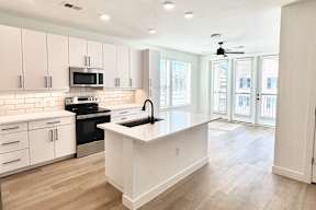 A modern kitchen with white cabinets and a central island.