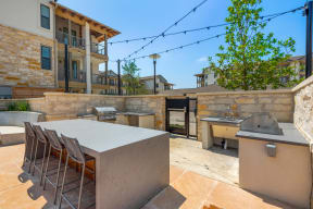 the backyard has a large table with chairs and a barbecue grill