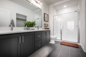 a black and white bathroom with a shower and sink