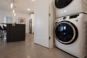 a front loading washer and dryer in a kitchen next to a laundry room