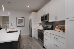an open kitchen with white cabinets and black appliances and a sink