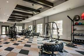A gym with a variety of equipment including weights and a treadmill.