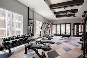 A gym with a variety of equipment including weights and a treadmill.