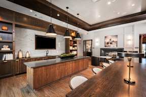 A modern kitchen with a wooden island and bar stools.