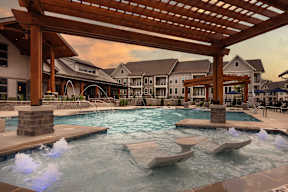 A large outdoor pool with a wooden pergola over it.