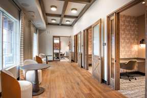 A long hallway with wood floors and a mix of white and wood walls.
