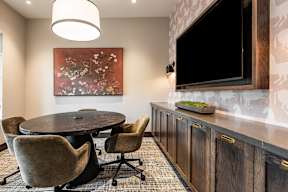A modern dining room with a round table and chairs.