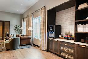 A modern kitchen with a black fridge and wooden cabinets.