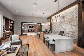 A modern living room with a white marble countertop and a brick wall.