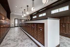 A long hallway with a row of mailboxes on the wall.