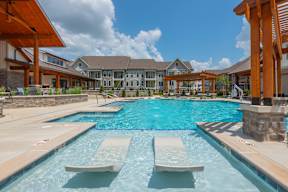 A large outdoor swimming pool with sun loungers.