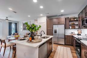 A modern kitchen with a white island and stainless steel appliances.