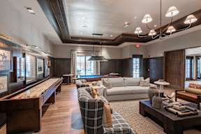 A living room with a pool table and a couch.