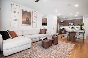 A modern living room with a white couch and brown coffee table.