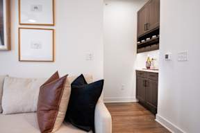 A living room with a white couch and brown pillows.