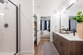 A bathroom with a walk-in shower and double sinks.