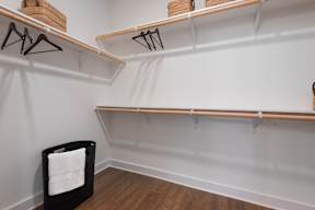 A room with two shelves and a black chair with white towels on it.