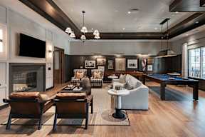 A modern living room with a pool table and a fireplace.